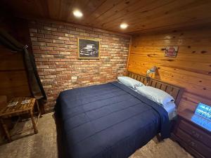 a bedroom with a blue bed in a brick wall at The Beach Cave in Santa Rosa Beach
