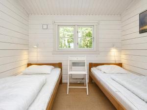 two beds in a small room with a window at Holiday home Fanø LII in Fanø