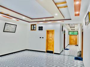 a hallway with white walls and wooden doors at The Abbott Crown Hotel Rajwal in Kāgān