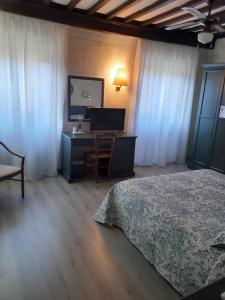 a bedroom with a bed and a desk with a computer at Hotel Borgo Antico in Bibbiena