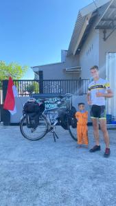 a man and a boy standing next to a bike at Juliana HomeStay 