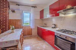 une cuisine avec des placards rouges et un comptoir dans l'établissement Lucija with mountain and seaview, à Metajna