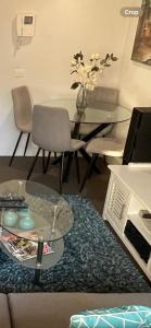 a living room with a glass table and a glass coffee table at Modern Luxurious with private parking on premises and fast internet in Melbourne