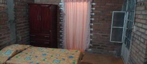 a bedroom with a bed and a brick wall at Villas Carmelita hostal in Paso de las Palmas