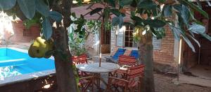 a patio with a table and chairs and a pool at Villas Carmelita hostal in Paso de las Palmas