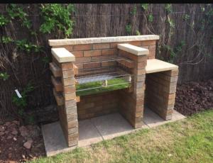 a brick bench in a yard with a fence at Villas Carmelita hostal in Paso de las Palmas