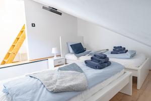 duas camas num quarto branco com toalhas em Via Paradiso Apartments em Piran