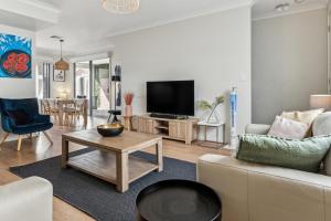 a living room with a couch and a tv at West Croydon Condo in Woodville