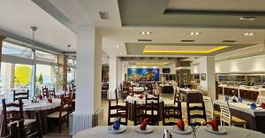 a restaurant with tables and chairs in a room at Hotel Enkelana in Pogradec