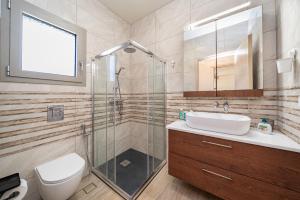 a bathroom with a shower and a sink and a toilet at Villa Elia Kefalonia by Olea Villas in Argostoli +33 photos