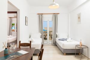 1 dormitorio con 2 camas, escritorio y mesa en Thelèsi Apartments, en Stalós