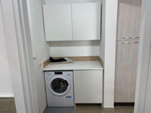 a washer and dryer in a kitchen with a white cabinet at Case Ariosto in Pozzallo
