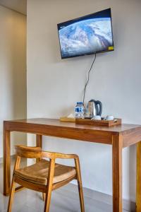 a wooden desk with a chair and a television on a wall at The Kanka Beach House in Nusa Penida +20 photos