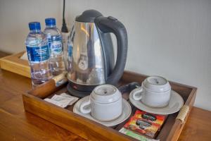 a tray with a tea kettle and cups on a table at The Kanka Beach House in Nusa Penida