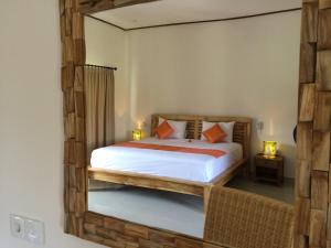 Schlafzimmer mit einem Bett und einem Spiegel an der Wand in der Unterkunft d'Sawah Amed Homestay & Warung in Amed