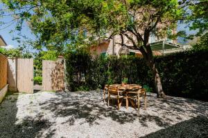 a table and chair in a yard with a tree at Forte 01 in Forte dei Marmi