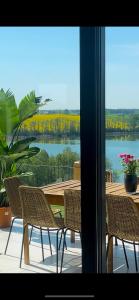 patio con tavolo, sedie e vista sul lago di Chojno 31- dom wypoczynkowy przy jeziorze z jacuzzi a Chrostkowo