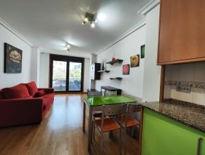 a living room with a red couch and a green table at Apartamento centro Nigrán in Nigrán +9 photos