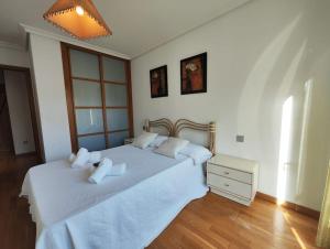 a bedroom with a large white bed with white pillows at Apartamento centro Nigrán in Nigrán