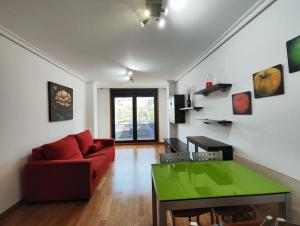 a living room with a red couch and a green table at Apartamento centro Nigrán in Nigrán