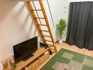 - un salon avec une télévision et une échelle dans l'établissement SAKURA Stay FUKUOKA2, à Fukuoka