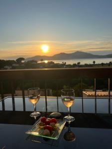 twee glazen wijn op een tafel met zonsondergang bij Appartement T2 vue mer in Porticcio