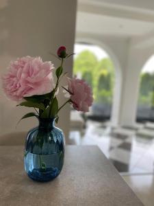 eine blaue Vase mit rosa Blumen auf einem Tisch in der Unterkunft DOM DENARI in Stará Turá
