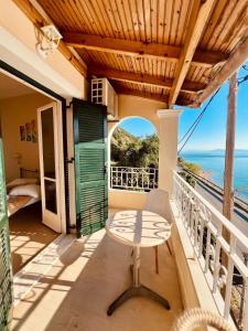 balcón con mesa y vistas al océano en IONIAN MARE, en Agios Ioannis Peristerion