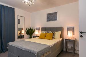 1 dormitorio con 1 cama grande con almohadas amarillas en Villa Del Mar Omiš, en Omiš