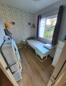 a small room with a bed and a window at MH126 Charmant mobilhome campagne des Yvelines in Saint-Illiers-la-Ville +13 photos