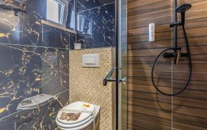 La salle de bains est pourvue d'une douche et de toilettes. dans l'établissement Villa San Rocco Bed & Breakfast, à Medulin