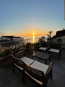 a sunset on a balcony with chairs and tables at Casa Vacanze Arya in Capo dʼOrlando