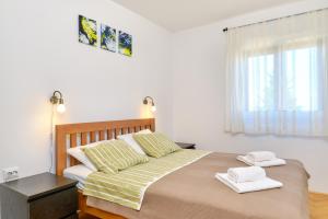 a bedroom with a large bed with two towels on it at Argo Apartmani in Mali Lošinj
