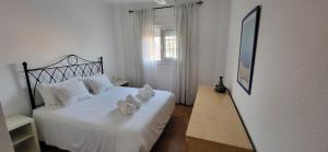 a bedroom with a white bed with towels on it at Apartamento Las Dunas de Isla Canela in Isla Canela +26 photos