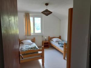 een slaapkamer met twee bedden en een raam bij Bellavie2 in La Bresse