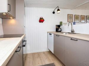 Nørre Vorupørにある6 person holiday home in Thistedの白いキャビネットとシンク付きのキッチン