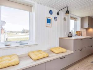 Nørre Vorupørにある6 person holiday home in Thistedのキッチン(黄色い枕2つ付)、窓