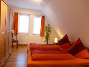 Diemelstadt にあるWetekams Ferienwohnung 4のリビングルーム(オレンジ色のソファ、窓2つ付)