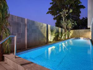 una piscina di fronte a un muro di Swiss-Belinn Simatupang a Giacarta