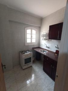 a small kitchen with a stove and a sink at El Obayed Apartments Armed Forces in Marsa Matruh