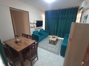 a dining room with a table and blue chairs at El Obayed Apartments Armed Forces in Marsa Matruh