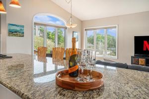 a bottle of champagne and glasses on a counter in a kitchen at Spacious 4BDR Blue Haven Cottage in Grand Haven 150 in Grand Haven
