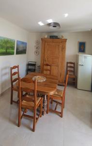 a kitchen with a wooden table and chairs and a refrigerator at Charmant appartement en Rez de jardin in Sartène +15 photos