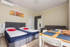a bedroom with two beds and a table and chairs at Studio Relax in Nida