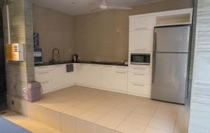 a kitchen with white cabinets and a refrigerator at Villa Lestari Legian in Legian