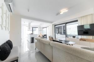 a living room with a large couch and a television at Villa Velebit - luxury apartment steps away from Adriatic Sea, with private pool and stunning views in Vinjerac