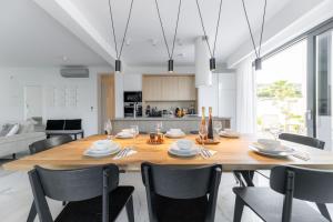 a kitchen and dining room with a wooden table and chairs at Villa Velebit - luxury apartment steps away from Adriatic Sea, with private pool and stunning views in Vinjerac