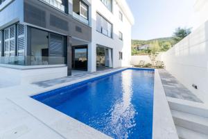 a swimming pool in the backyard of a house at Villa Velebit - luxury apartment steps away from Adriatic Sea, with private pool and stunning views in Vinjerac
