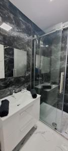 een badkamer met een wastafel en een glazen douche bij PrimRose Lux Loft in Xewkija +7 foto's
