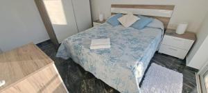 a bedroom with a bed with a blue comforter at PrimRose Lux Loft in Xewkija